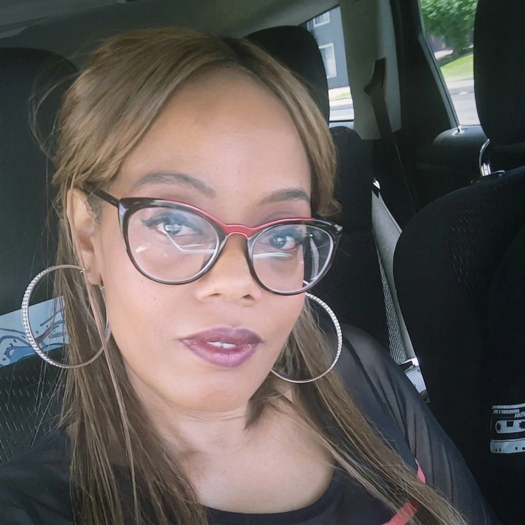 Cherise Franklin in red-and-black cat-eye glasses and silver hoop earrings